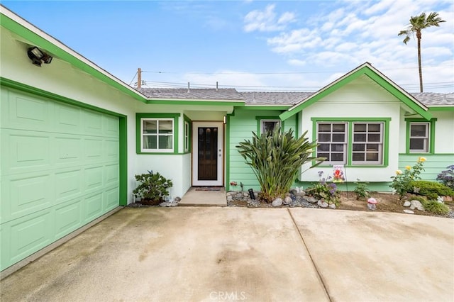 ranch-style house featuring an attached garage, a shingled roof, driveway, and stucco siding