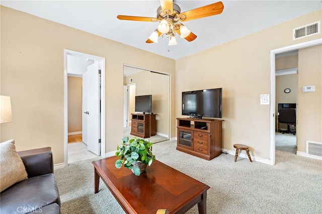 carpeted living area featuring ceiling fan and baseboards