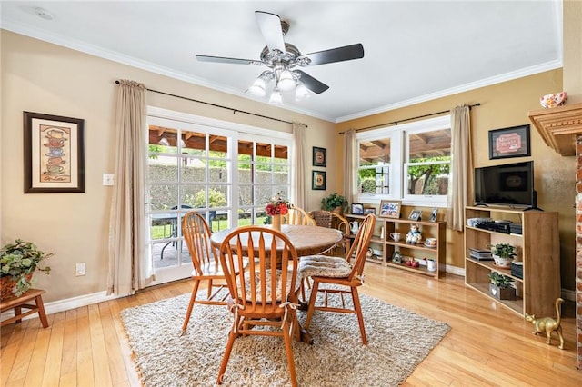 dining room featuring ornamental molding, light wood finished floors, baseboards, and a ceiling fan