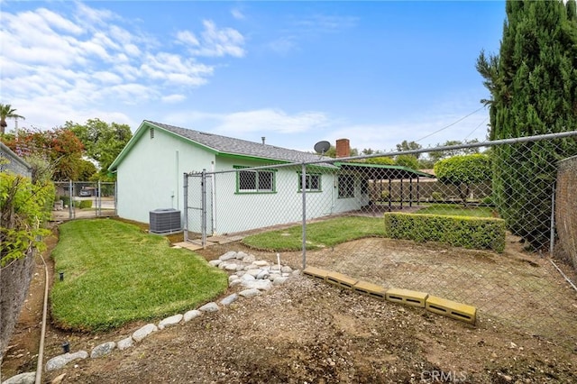 back of property with a gate and central AC
