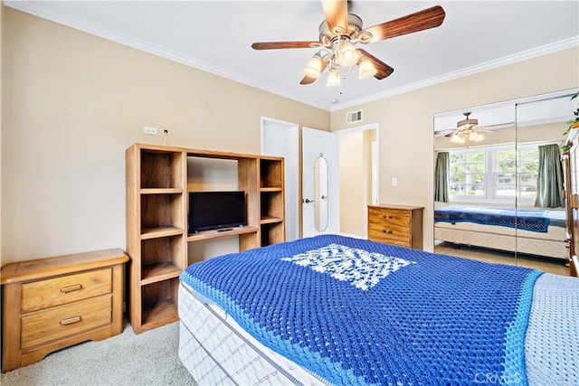 bedroom featuring ornamental molding, carpet flooring, a closet, and ceiling fan