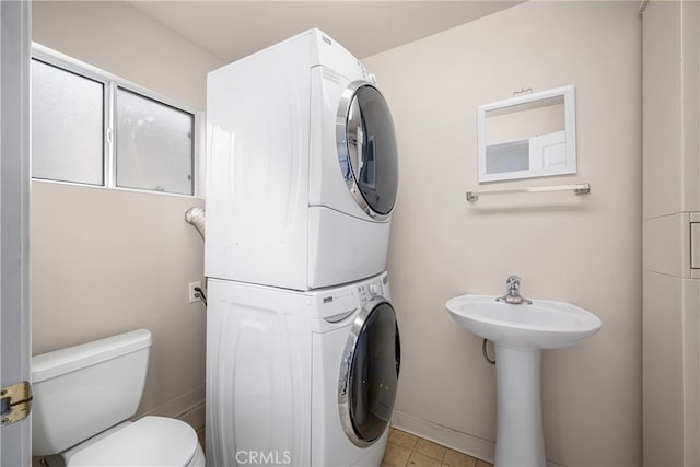 3113 San Anseline Ave, Long Beach, CA 90808 - bathroom featuring stacked washer and clothes dryer, toilet, baseboards, a sink, and tile patterned flooring