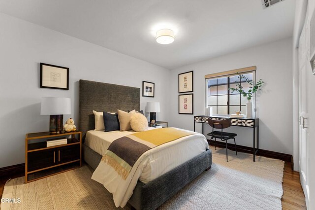 bedroom featuring wood finished floors and baseboards