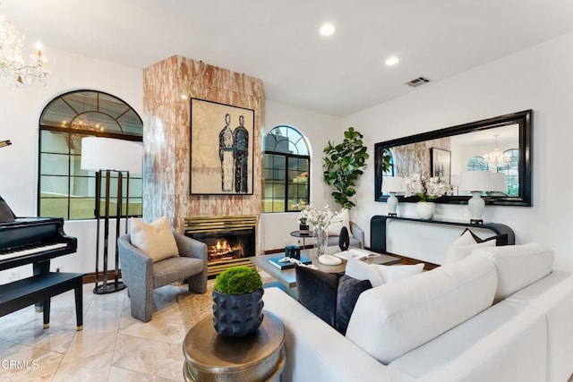 living room featuring a chandelier, a large fireplace, and recessed lighting