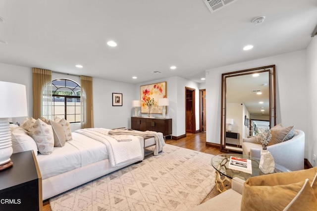 bedroom with wood finished floors, recessed lighting, and baseboards