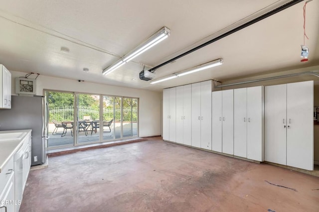 garage with a garage door opener and freestanding refrigerator