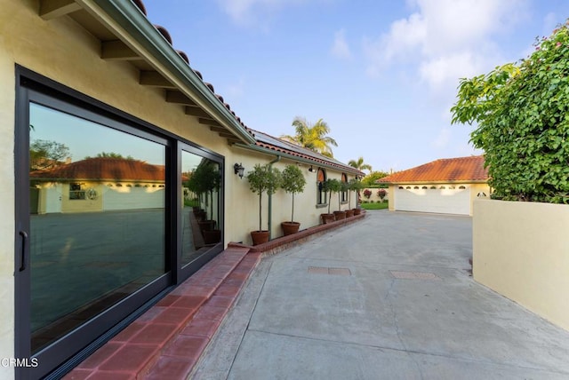 view of home's exterior with stucco siding, an outbuilding, and a garage