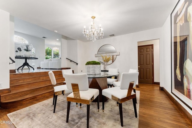 dining space with a chandelier and wood finished floors