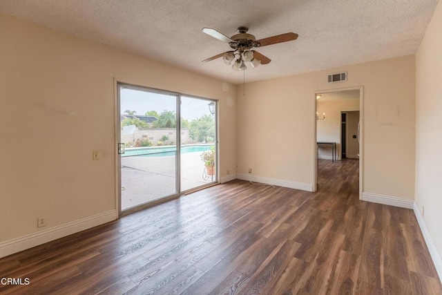 empty room featuring a textured ceiling, wood finished floors, a ceiling fan, and baseboards