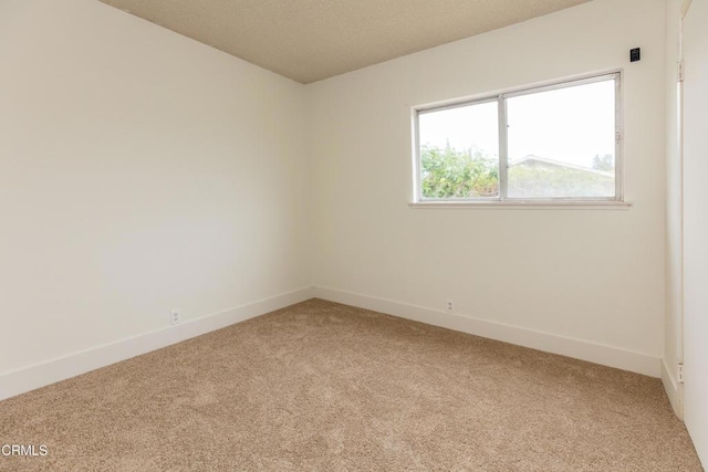 unfurnished room featuring light colored carpet and baseboards