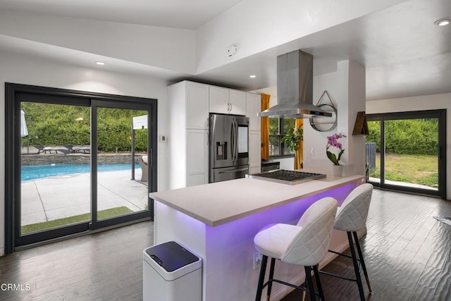 1445 Washburn Rd, Pasadena, CA 91105 - kitchen featuring stainless steel fridge, island range hood, plenty of natural light, white cabinetry, and recessed lighting
