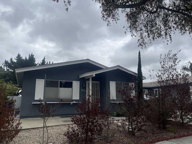 ranch-style home featuring stucco siding