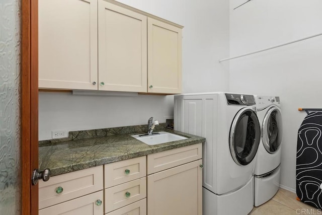 washroom featuring cabinet space, washing machine and dryer, and light tile patterned floors