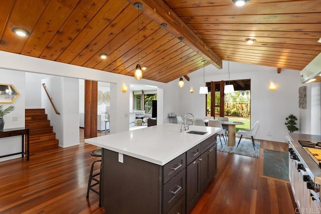 kitchen with a sink, dark wood-style floors, healthy amount of natural light, light countertops, and wood ceiling