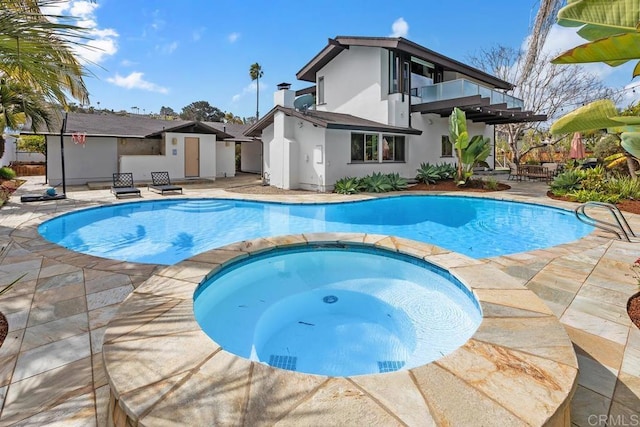 view of swimming pool with a patio area and a pool with connected hot tub