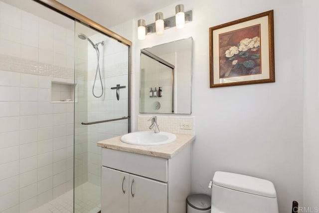 bathroom with a shower stall, backsplash, toilet, and vanity