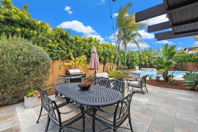 view of patio / terrace with outdoor dining space, a fenced backyard, and area for grilling