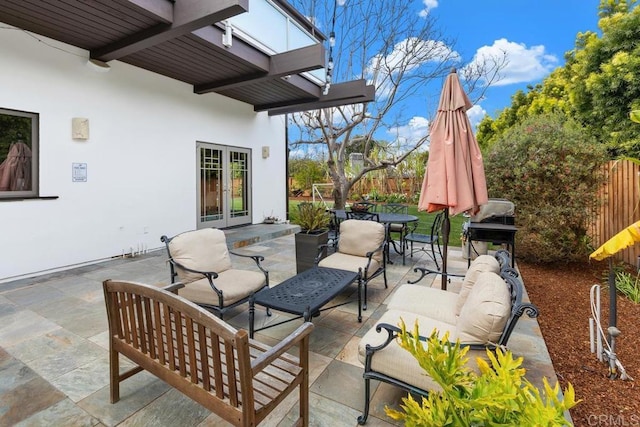 view of patio with an outdoor hangout area, fence, outdoor dining space, and french doors