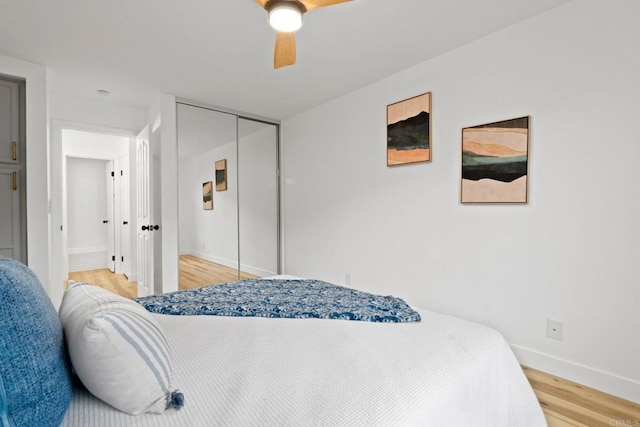 bedroom featuring light wood-style flooring, baseboards, a closet, and a ceiling fan