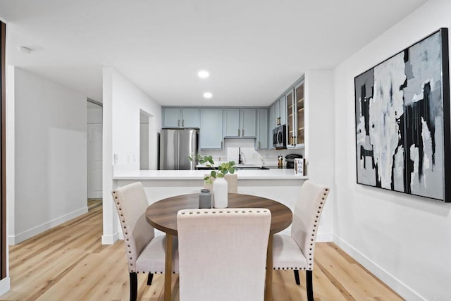 dining space featuring baseboards, light wood-style floors, and recessed lighting