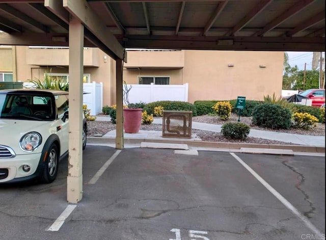 covered parking lot featuring fence