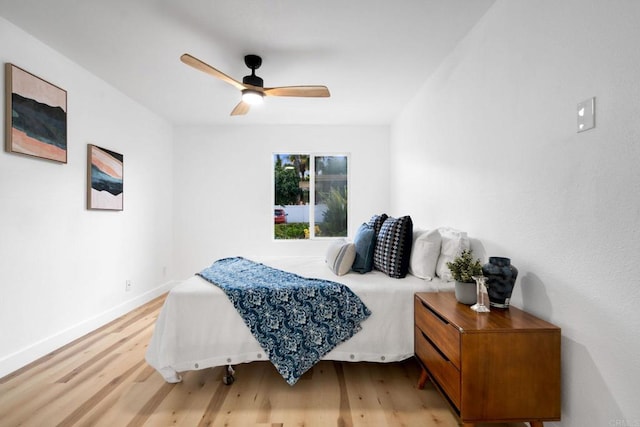 bedroom featuring light wood-style floors, baseboards, and a ceiling fan