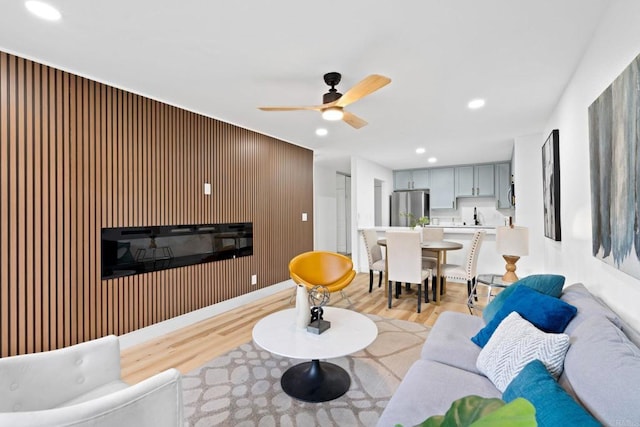 living area featuring light wood-style flooring, ceiling fan, and recessed lighting