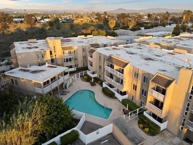aerial view at dusk of view of pool area and a mountain view