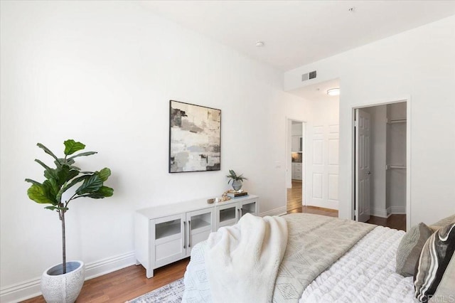 12370 Carmel Country Rd Unit 305, San Diego, CA 92130 - bedroom featuring wood finished floors, baseboards, and a walk in closet