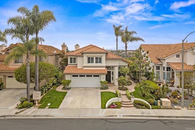 mediterranean / spanish home with a garage, a tile roof, driveway, and stucco siding