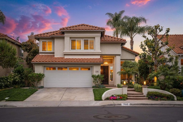 mediterranean / spanish house featuring stucco siding, concrete driveway, a garage, and a tiled roof