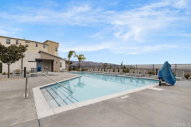 community pool featuring fence, central air condition unit, and a patio area