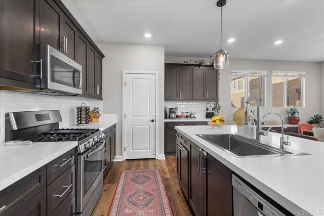 1840 Mint Unit 6, Chula Vista, CA 91915 - kitchen with appliances with stainless steel finishes, light countertops, dark wood-style flooring, dark brown cabinetry, and recessed lighting