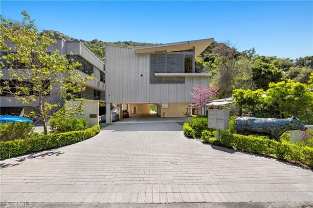 view of front of house with decorative driveway and a carport