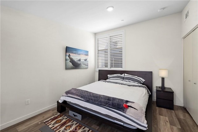 bedroom featuring wood finished floors, a closet, and baseboards