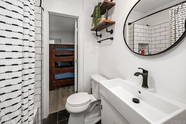 full bathroom featuring toilet, vanity, and curtained shower