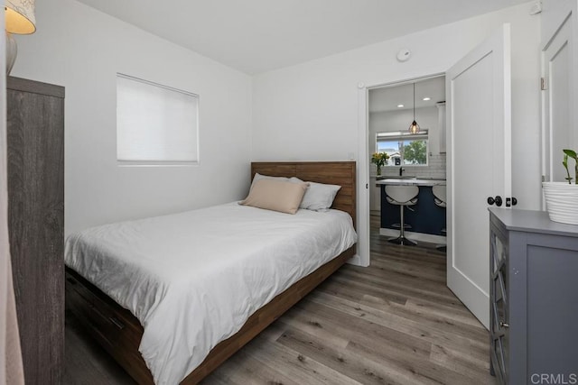 bedroom featuring wood finished floors and connected bathroom