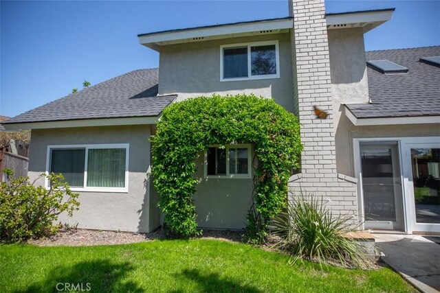 24111 Marathon St, Mission Viejo, CA 92691 - rear view of house with roof with shingles, a chimney, stucco siding, brick siding, and a yard