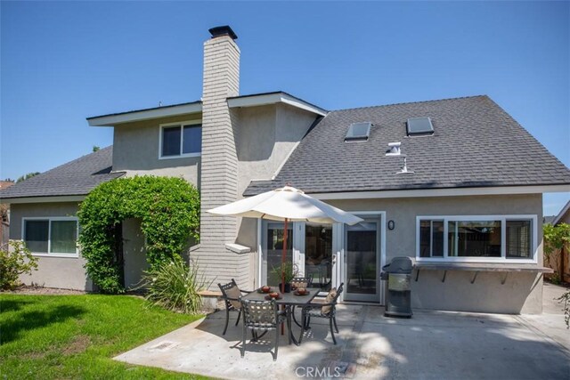 24111 Marathon St, Mission Viejo, CA 92691 - back of house featuring stucco siding, a patio, a chimney, and a lawn