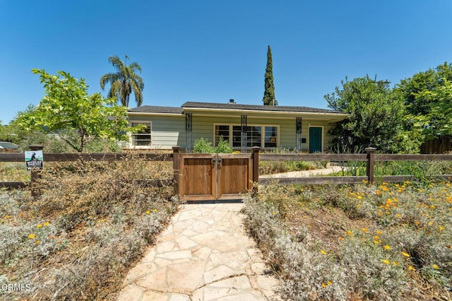 ranch-style house featuring a fenced front yard and a gate