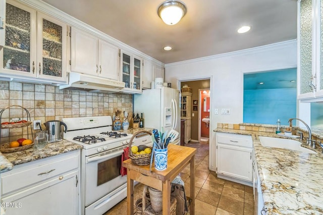 kitchen with under cabinet range hood, white appliances, tasteful backsplash, crown molding, and white cabinets