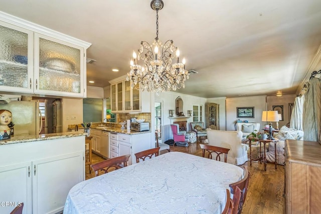 dining room featuring dark wood-style floors, ornamental molding, a chandelier, and recessed lighting