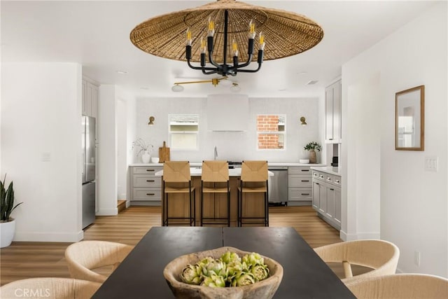 2153 Stanbridge Ave, Long Beach, CA 90815 - dining space featuring light wood finished floors, a chandelier, and baseboards