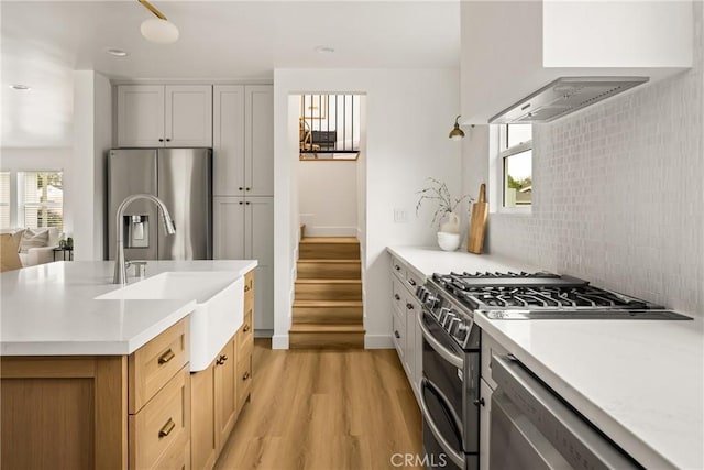 2153 Stanbridge Ave, Long Beach, CA 90815 - kitchen with appliances with stainless steel finishes, a sink, light wood finished floors, custom range hood, and recessed lighting
