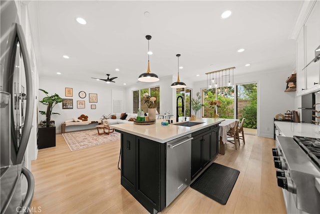54 Painted Cameo, Irvine, CA 92602 - kitchen with appliances with stainless steel finishes, dark cabinets, light countertops, white cabinetry, and light wood finished floors