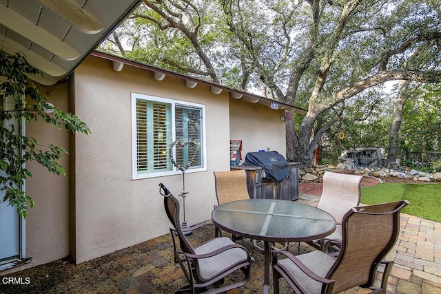view of patio with outdoor dining area, area for grilling, and fence