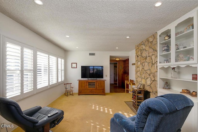 living area with a textured ceiling, recessed lighting, and carpet floors