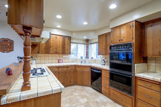 kitchen with black appliances, tile counters, backsplash, brown cabinets, and recessed lighting