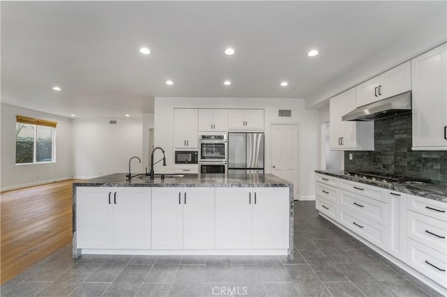 6 Heatherwood, Irvine, CA 92620 - kitchen featuring appliances with stainless steel finishes, under cabinet range hood, a sink, dark stone counters, and recessed lighting
