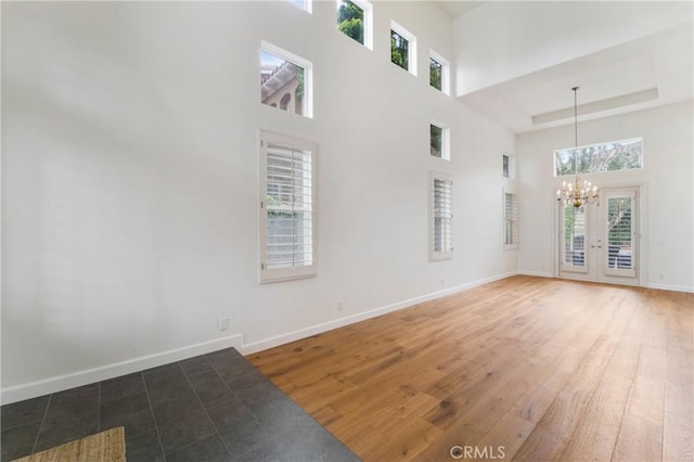 6 Heatherwood, Irvine, CA 92620 - spare room with a chandelier, plenty of natural light, a towering ceiling, baseboards, and wood finished floors